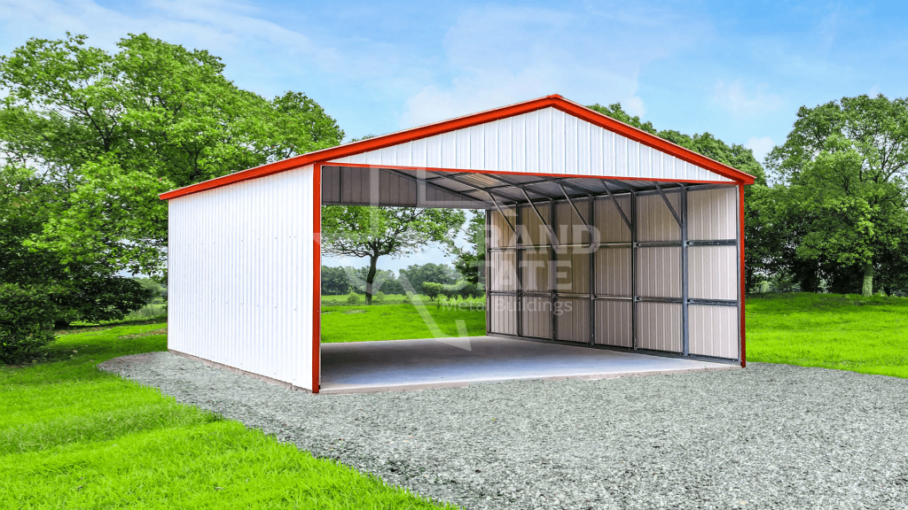 Metal RV carport featuring white steel panels, red trim, an open front, and a gravel base surrounded by green landscape.